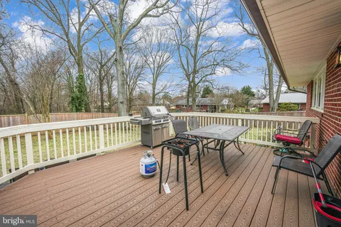 a view of a roof deck with table and chairs wooden floor and fence