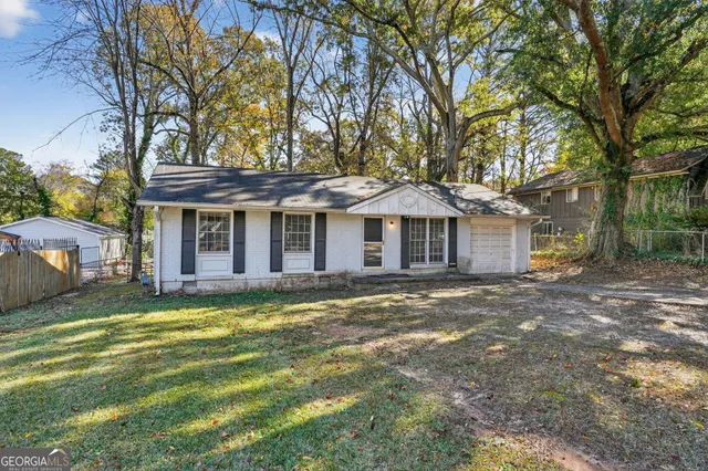 a front view of a house with a garden and trees