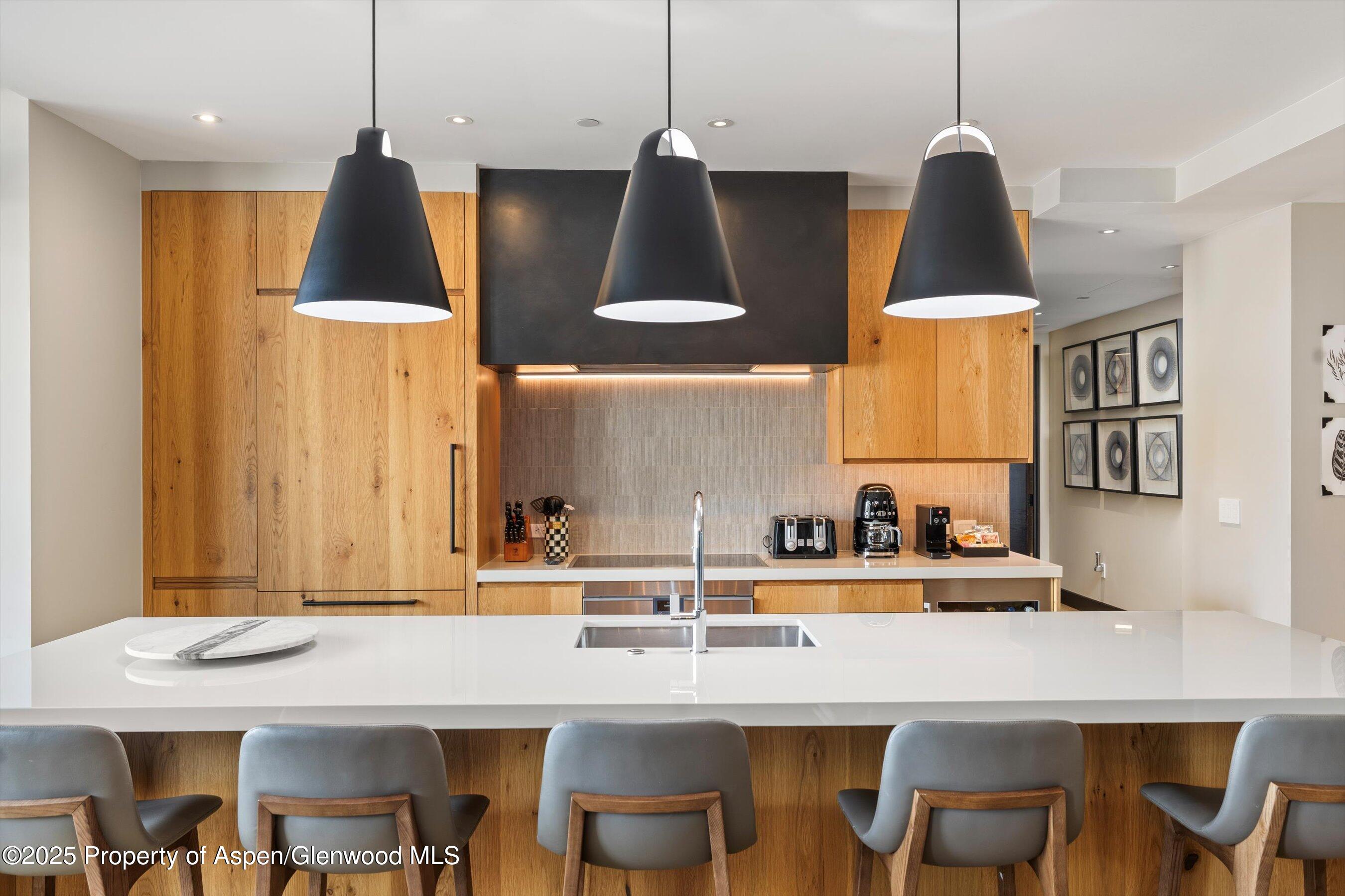 77 Wood Road, Unit 303 Snowmass Village, CO 81615 - Photo 11 of 43 a kitchen with a table and chairs in it