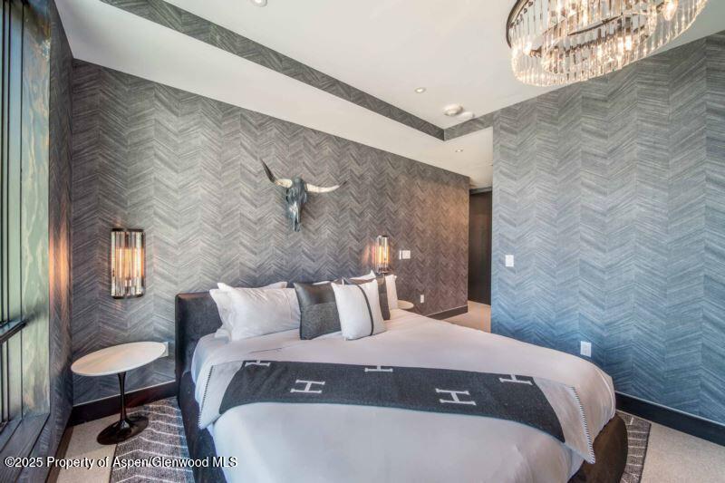 77 Wood Road, Unit 303 Snowmass Village, CO 81615 - Photo 14 of 43 a bedroom with a bed and a table in it