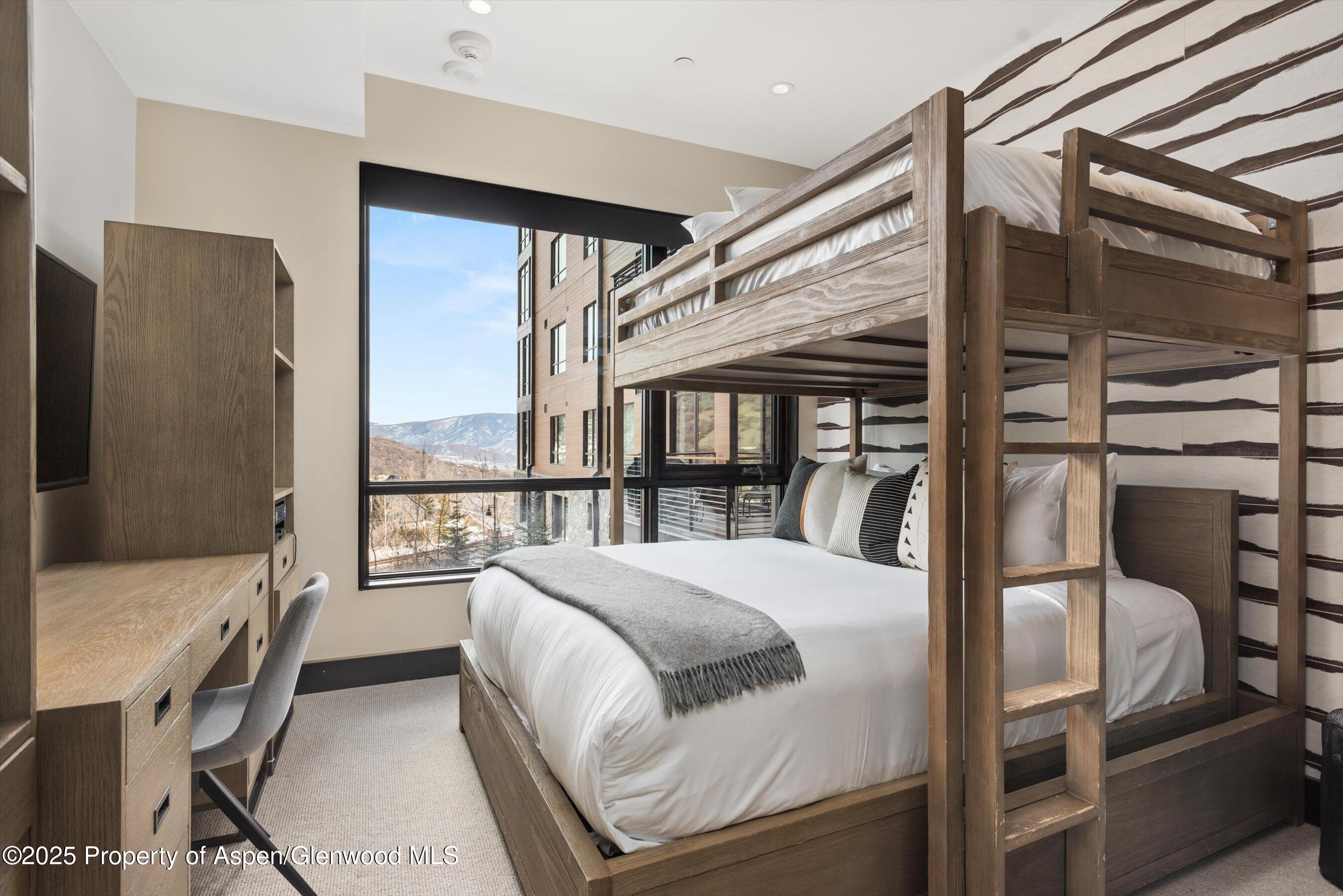 77 Wood Road, Unit 303 Snowmass Village, CO 81615 - Photo 22 of 43 a bedroom with a bed and a large window