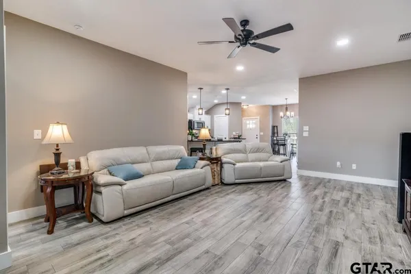 a living room with furniture and a wooden floor
