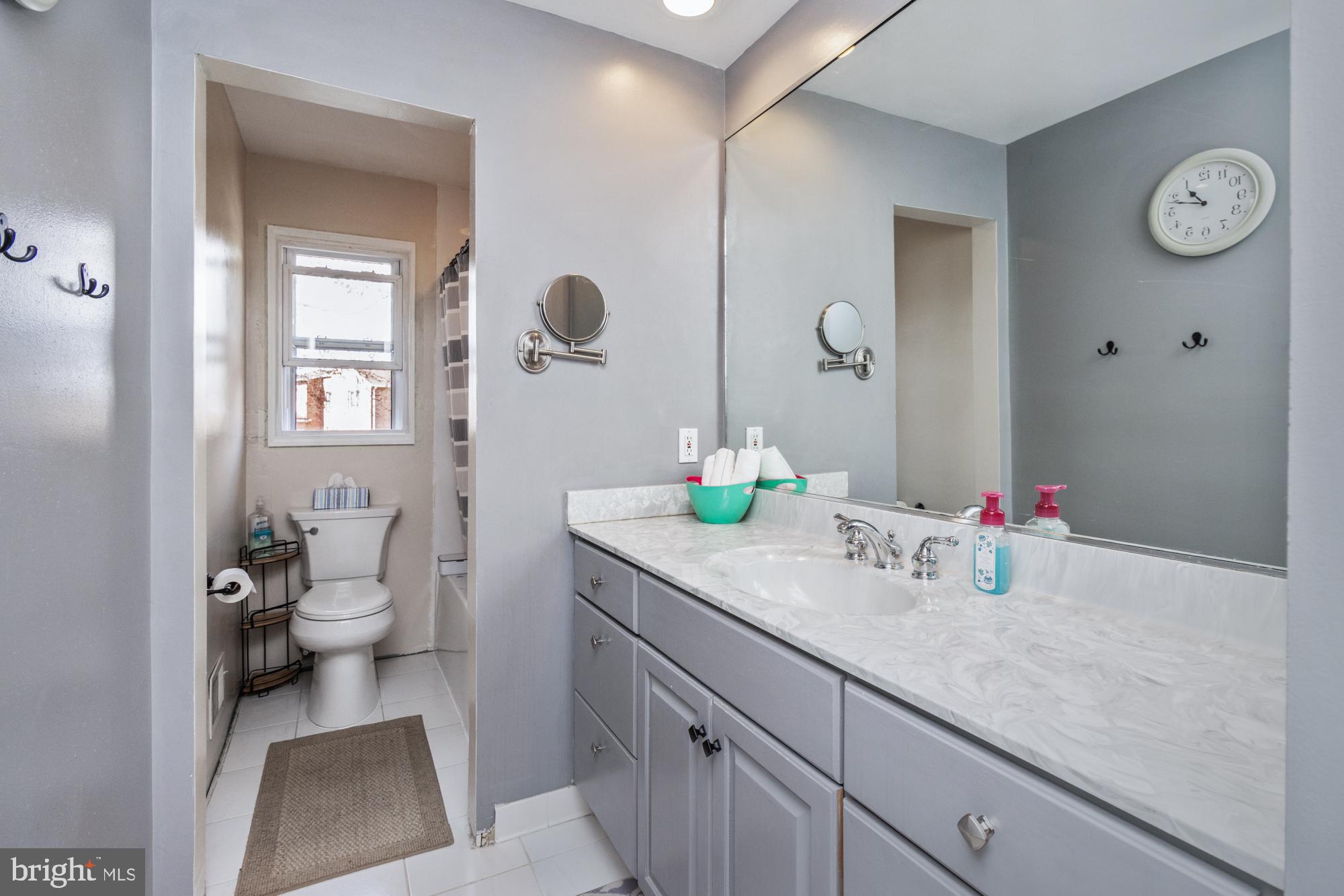 9202 Santa Rita Road Baltimore, MD 21236 - Photo 28 of 50 a bathroom with a granite countertop sink a toilet and a mirror