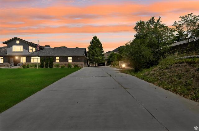 580 North 300 East Logan, UT 84321 - Photo 3 of 74 Expansive concrete driveway leading to a multi-level residence featuring brick and siding exterior construction