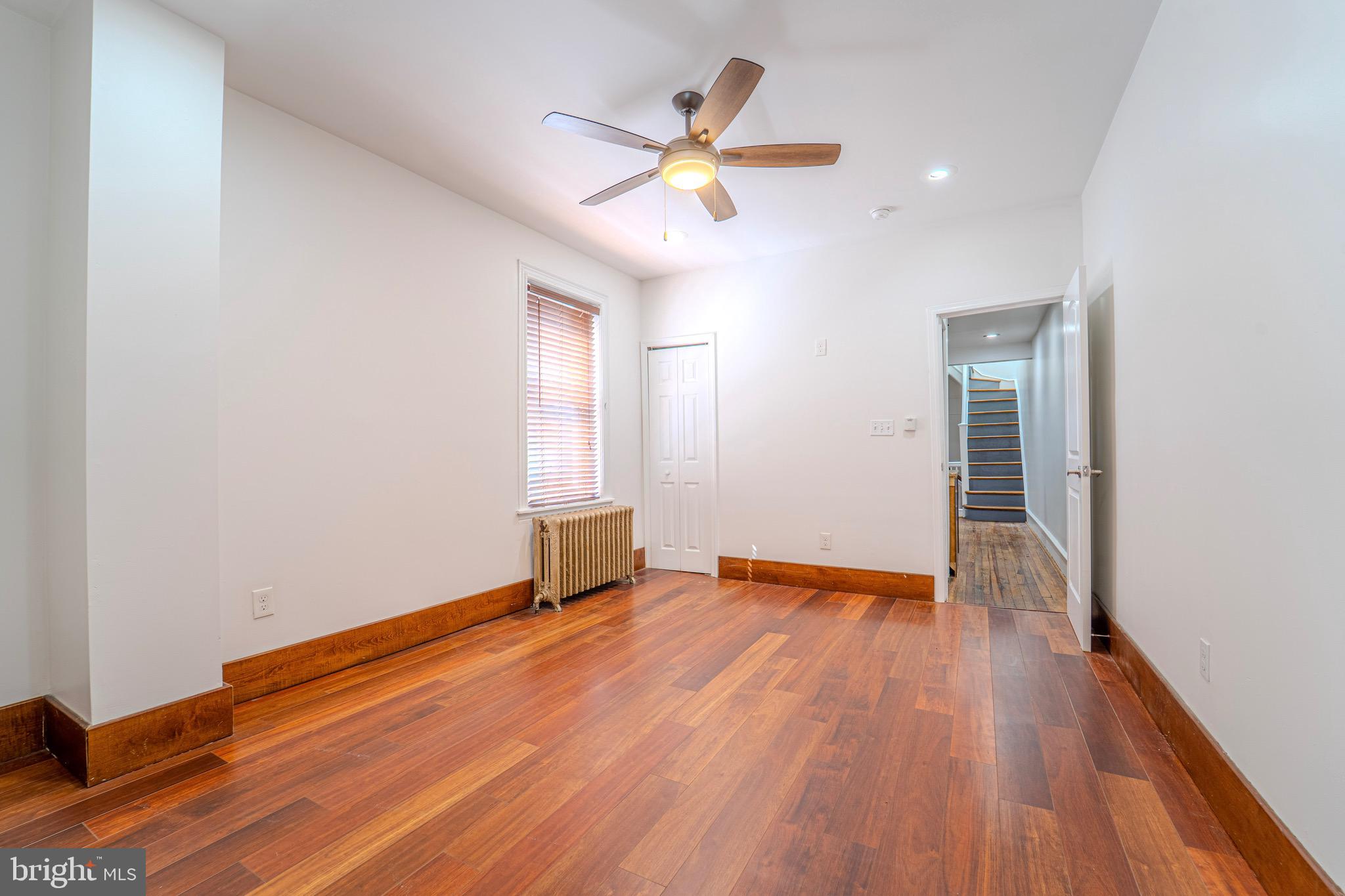 225 South 49th Street, Unit 2 Philadelphia, PA 19139 - Photo 12 of 26 a view of an empty room with wooden floor and a ceiling fan
