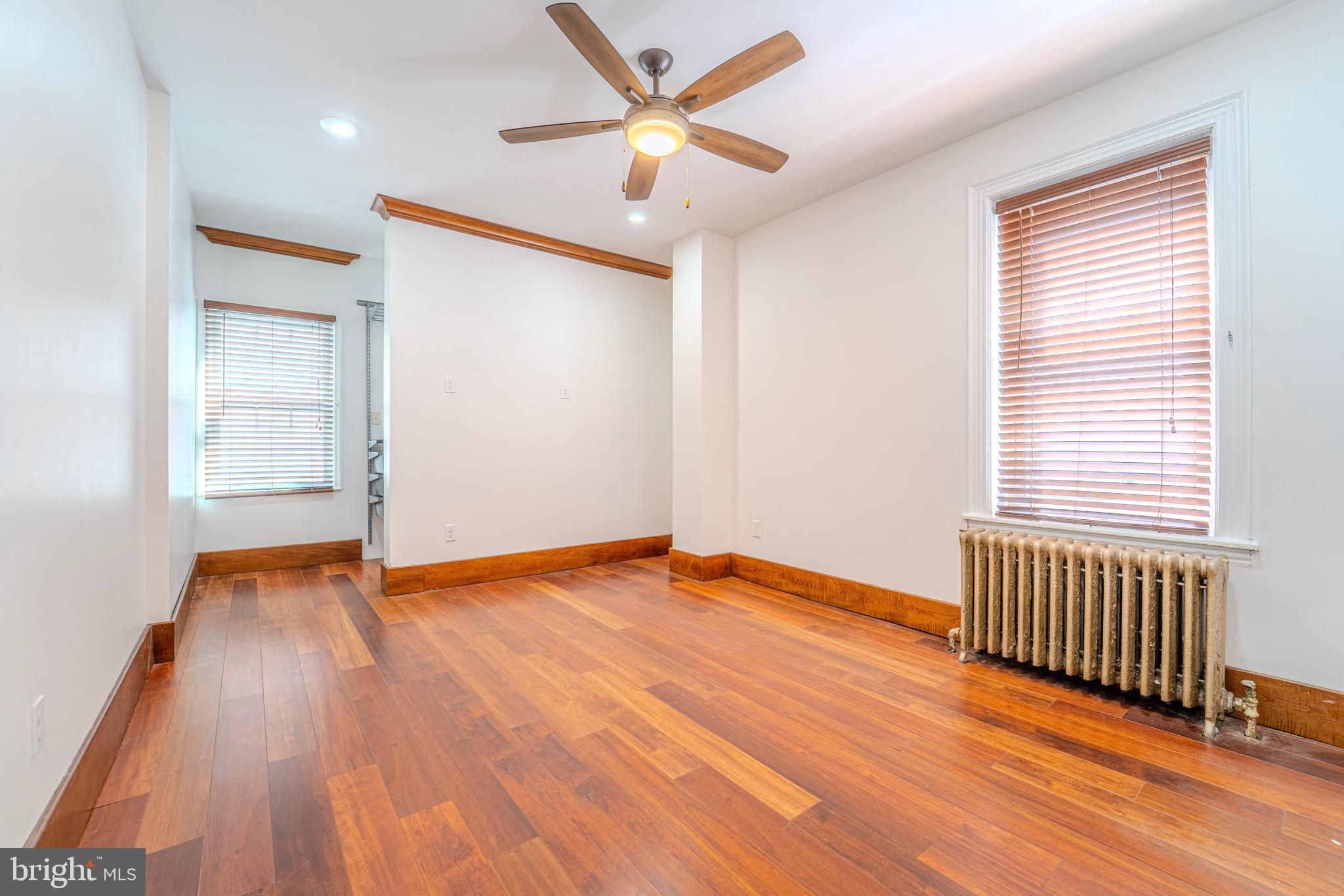 225 South 49th Street, Unit 2 Philadelphia, PA 19139 - Photo 15 of 26 an empty room with wooden floor and windows