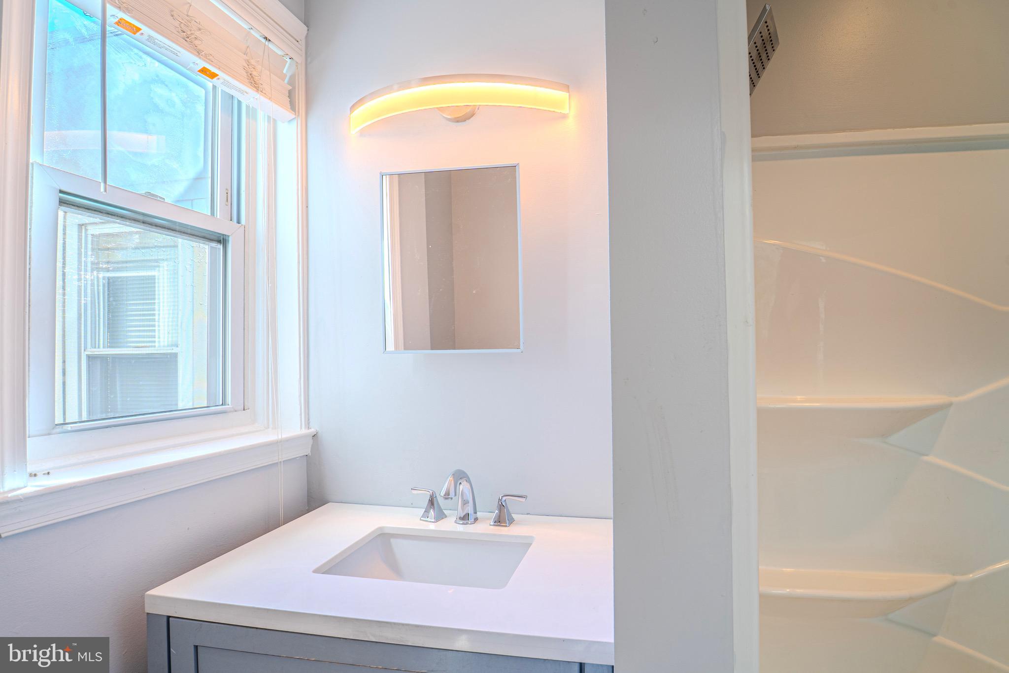 225 South 49th Street, Unit 2 Philadelphia, PA 19139 - Photo 18 of 26 a bathroom with a sink and a mirror