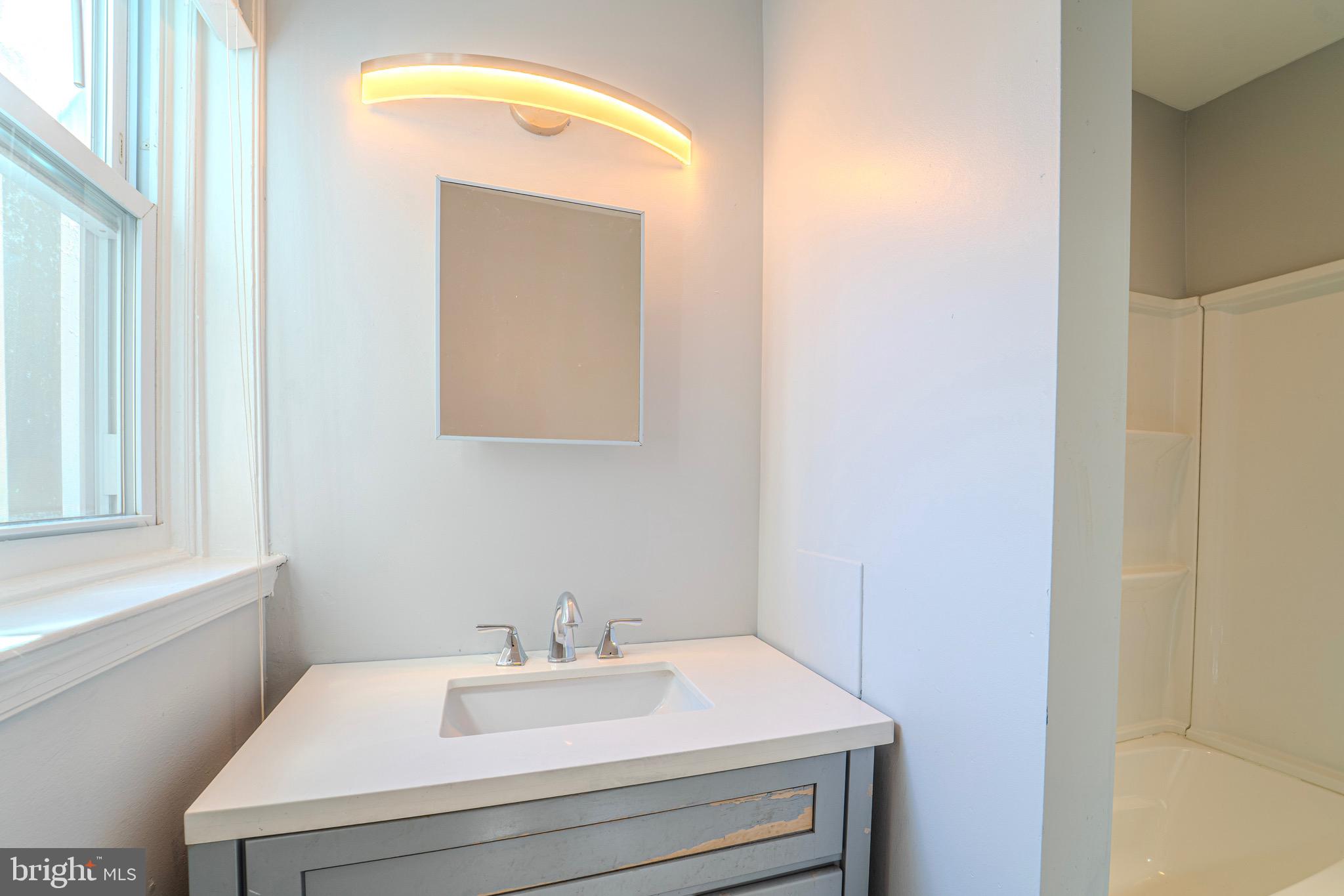 225 South 49th Street, Unit 2 Philadelphia, PA 19139 - Photo 20 of 26 a bathroom with a sink and a mirror