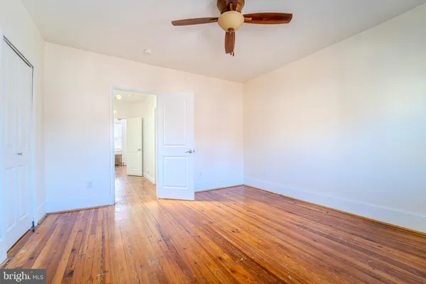 a view of empty room with wooden floor