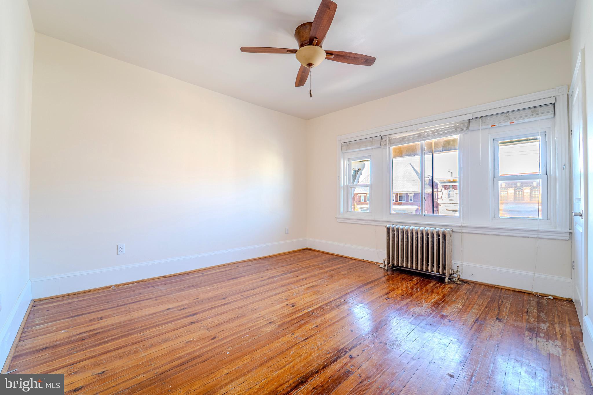 225 South 49th Street, Unit 2 Philadelphia, PA 19139 - Photo 23 of 26 a view of an empty room with wooden floor and a window