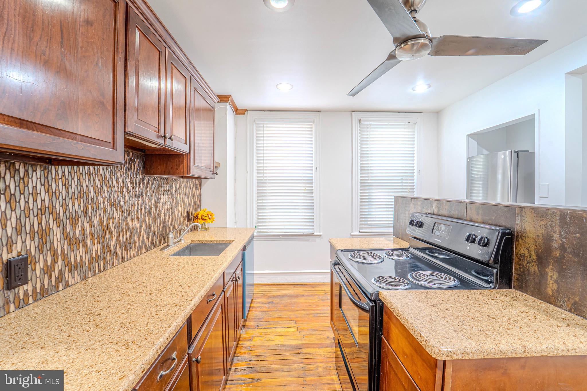 225 South 49th Street, Unit 2 Philadelphia, PA 19139 - Photo 7 of 26 a kitchen with a stove and a refrigerator