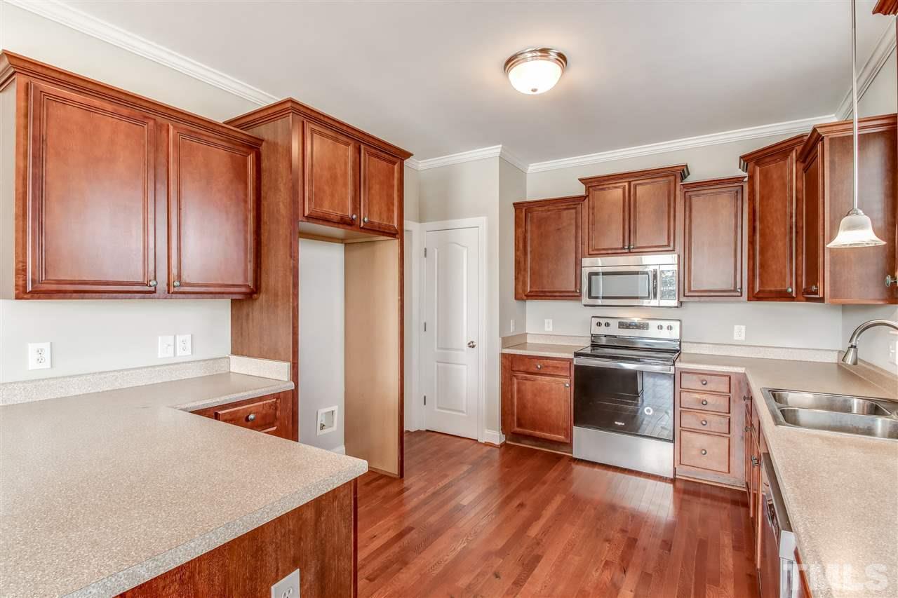 8905 Oregon Inlet Court Raleigh, NC 27603 - Photo 12 of 30 a kitchen with stainless steel appliances granite countertop a refrigerator stove top oven sink and cabinets with wooden floor