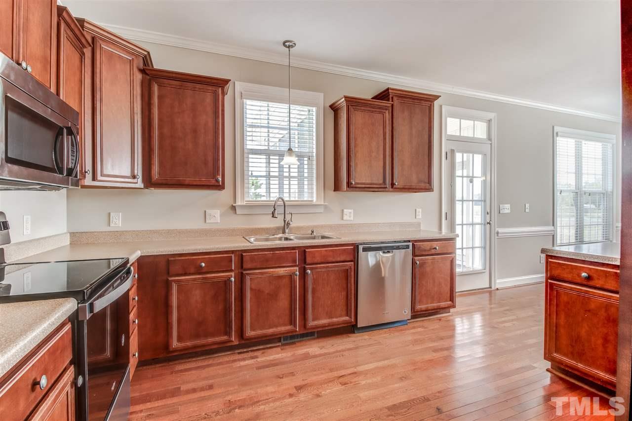 8905 Oregon Inlet Court Raleigh, NC 27603 - Photo 14 of 30 a kitchen with stainless steel appliances granite countertop wooden cabinets a sink and dishwasher a stove with wooden floor