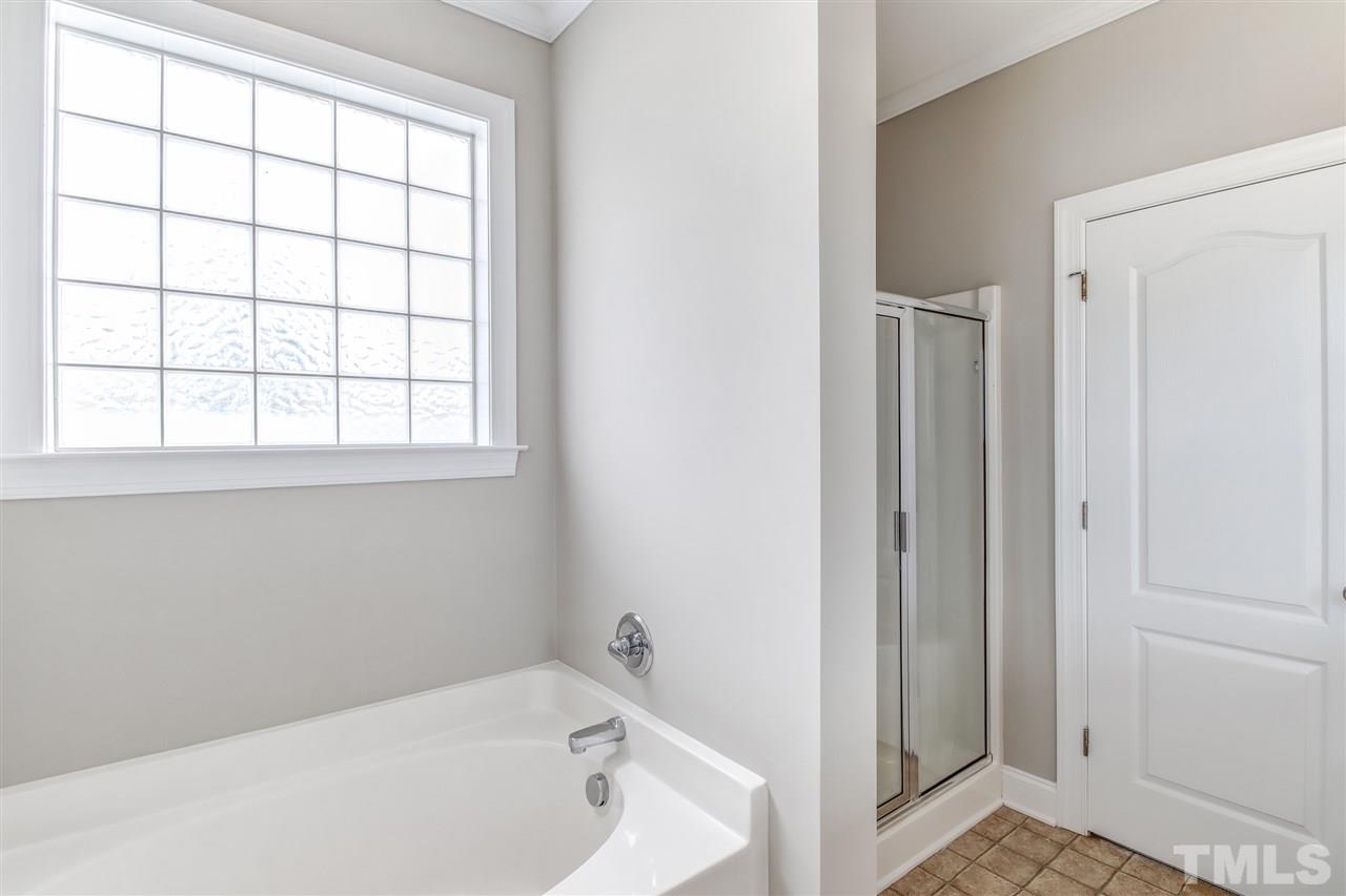 8905 Oregon Inlet Court Raleigh, NC 27603 - Photo 22 of 30 a bathroom with a bathtub and window