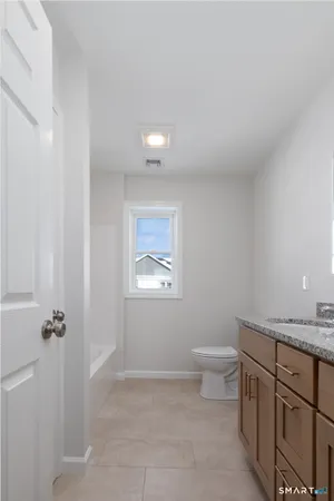 a bathroom with a granite countertop sink a toilet and a mirror