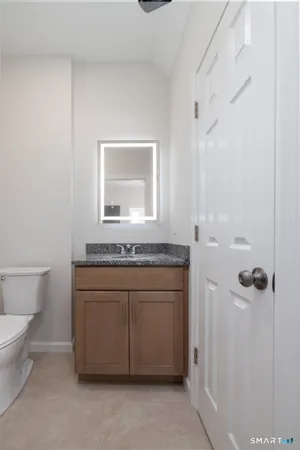a bathroom with a granite countertop sink a toilet and a mirror