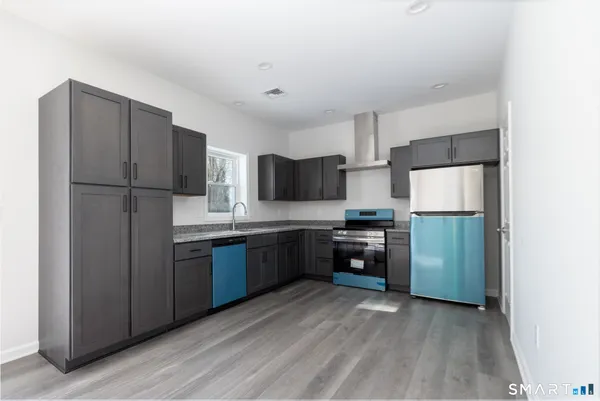 a kitchen with stainless steel appliances granite countertop a refrigerator stove and a sink