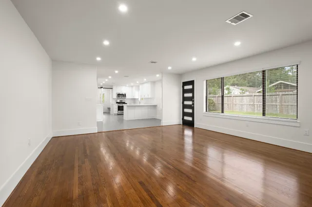 a view of large hall with wooden floor and windows