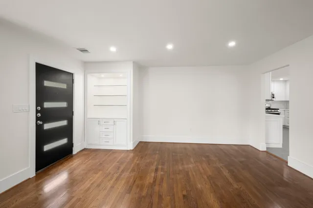 a view of empty room with wooden floor and closet