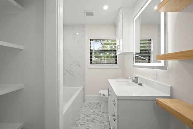 a bathroom with a sink a toilet and tub