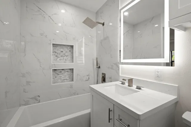 a bathroom with a sink vanity tub and a shower