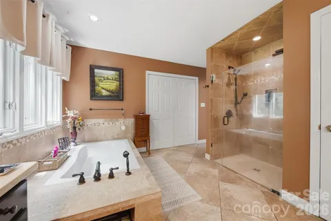a spacious bathroom with a double vanity sink a toilet and a tub
