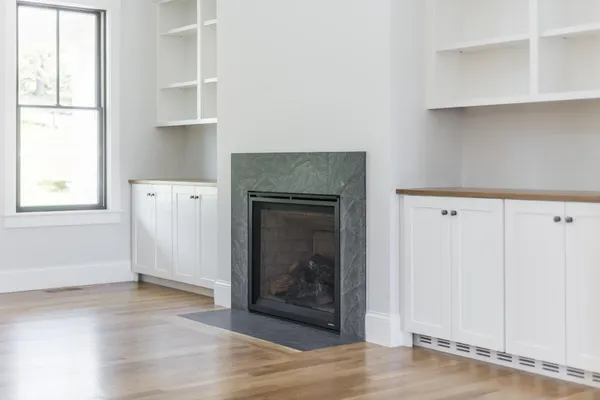 a view of a kitchen with wooden floor and a fireplace