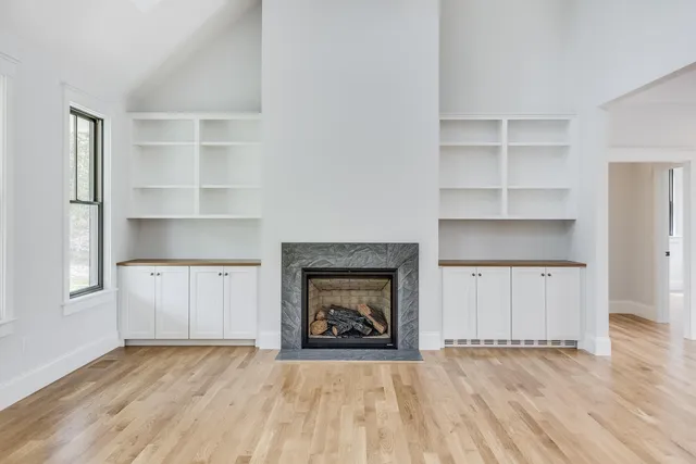 a view of an empty room with a fireplace and a window