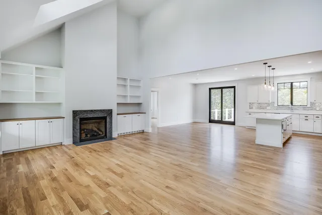 a view of an empty room with a fireplace and a window