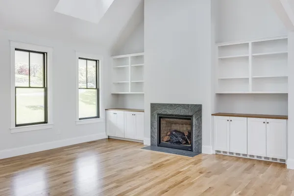 a view of an empty room with a fireplace and a window