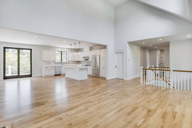 a large kitchen with cabinets wooden floor and stainless steel appliances