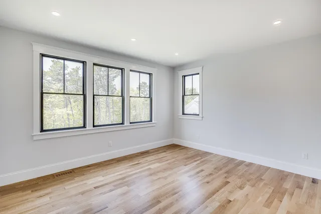 a view of empty room with wooden floor