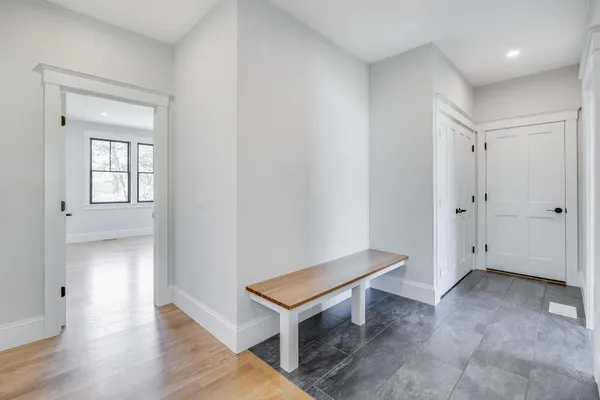 an empty room with wooden floor and windows with curtains