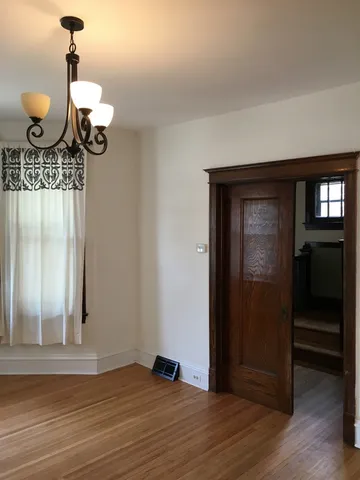 a view of a hallway with wooden floor and staircase