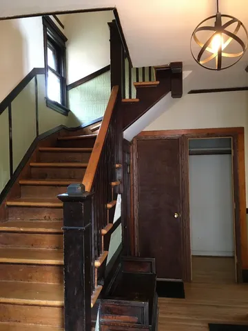 a view of entryway and hall with wooden floor