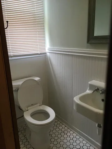 a white toilet sitting next to a small sink