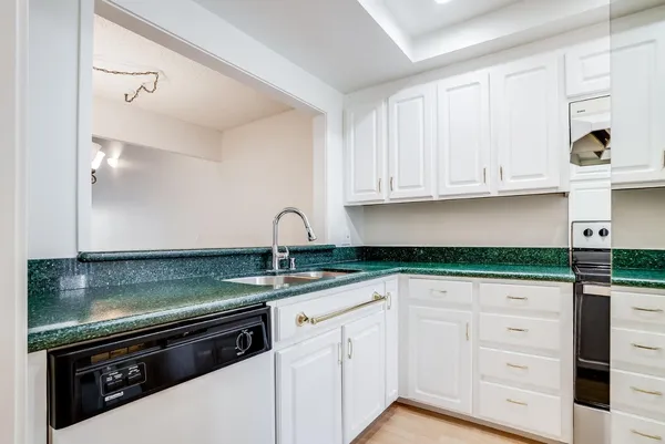 a view of a large kitchen with stainless steel appliances granite countertop a sink a stove and a window