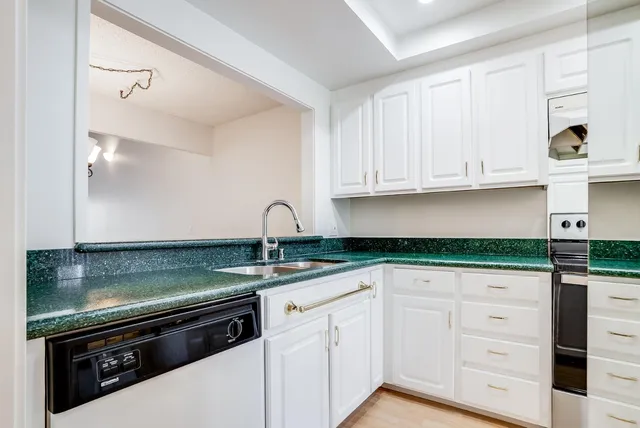 a view of a large kitchen with stainless steel appliances granite countertop a sink a stove and a window