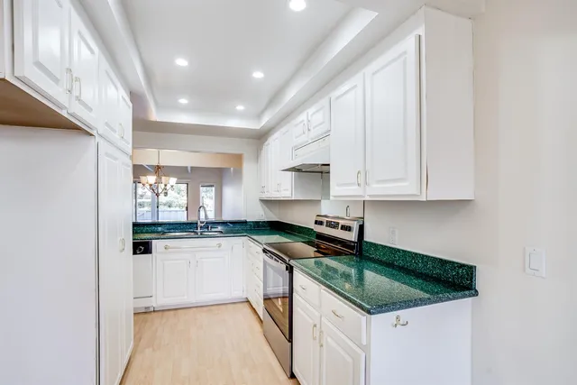 a kitchen with granite countertop white cabinets and white appliances