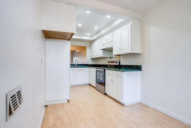 a kitchen with stainless steel appliances granite countertop a sink a stove and a granite counter tops
