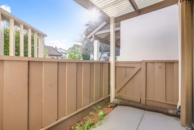 a view of a house with backyard and wooden fence