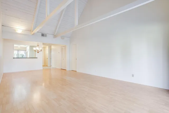 a view of a hallway with wooden floor and cabinet