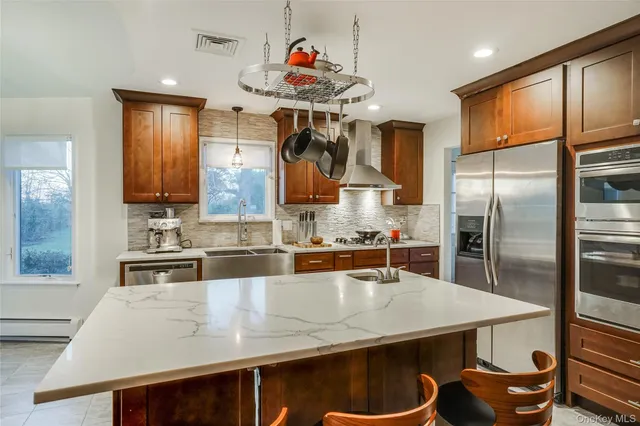 a kitchen with stainless steel appliances granite countertop a sink a stove and a refrigerator