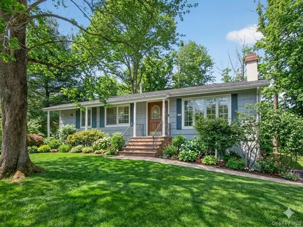 a front view of house with yard and green space