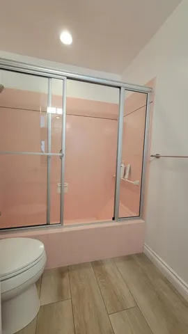 a bed room with a bed a flat screen tv and a refrigerator