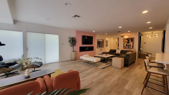 a kitchen with stainless steel appliances kitchen island granite countertop a table chairs and a living room