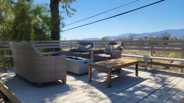 a patio with a table and chairs and potted plants