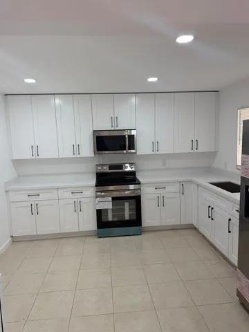 a kitchen with cabinets appliances and a sink