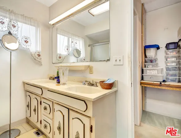 a utility room with cabinets a sink and a window