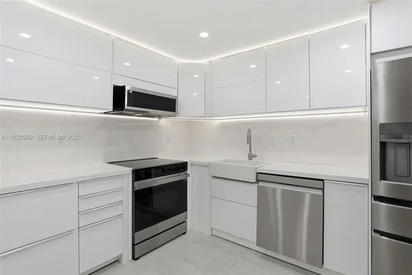 a kitchen with white cabinets and stainless steel appliances